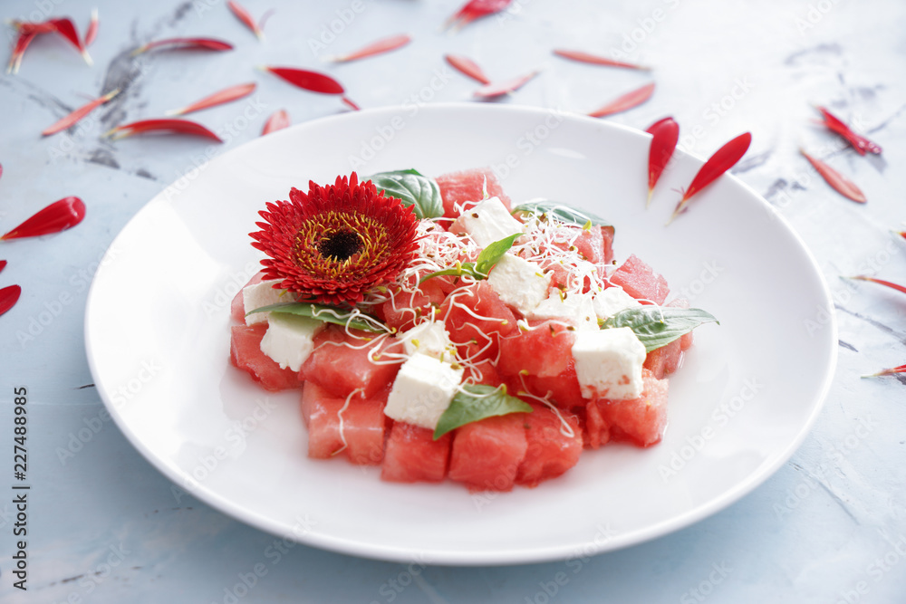 Plate with delicious watermelon salad on light table Plate with delicious watermelon salad on light table