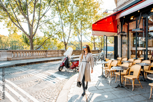 Street view with traditional french cafe and woman walking during the morning in Paris © rh2010