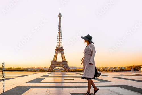 Woman dressed in coat and hat walking on the famous square with great view on the Eiffel tower early in the morning in Paris © rh2010