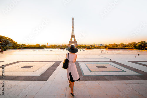 Woman dressed in coat and hat walking on the famous square with great view on the Eiffel tower early in the morning in Paris © rh2010