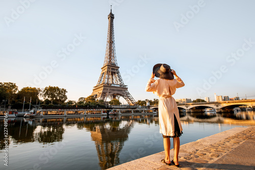 Young woman tourist enjoying landscape view on the Eiffel tower with beautiful reflection on the water during the mornign light in Paris © rh2010