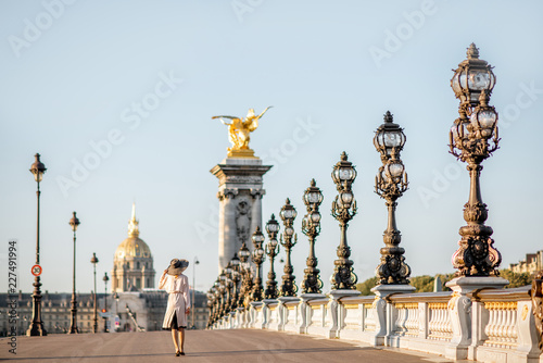 View on the famous Alexandre bridge with beautiful woman walking during the morning view in Paris