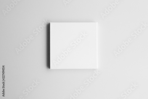 White square canvas on gray wall. Mock-up poster frame in interior.