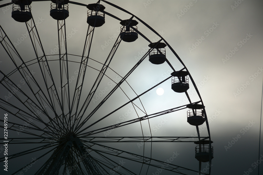 Sun rising through the mist of Ferris wheel