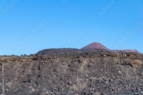 Looking over rocks of lava towards Teneguia Volcano, La Palma Island, The Canaries. Teneguia volcano last erupted in 1971