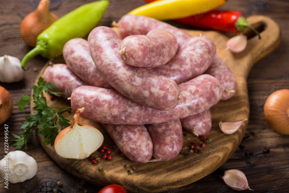 Raw sausages on the wooden board Raw sausages on the wooden board