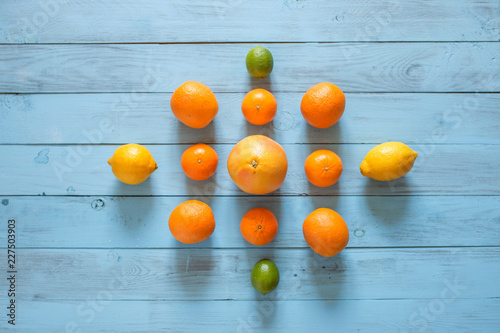 Whole citrus assorty of colourful fruits on the middle of blue wooden textured background. Top view. Copy space. photo