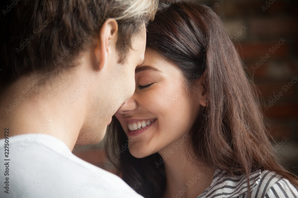 Head shot of young affectionate romantic couple in love. Close up portrait of attractive brunette girl and guy with eyes closed, close to each other. Concept of first kiss, tenderness and amorousness Head shot of young affectionate romantic couple in love. Close up portrait of attractive brunette girl and guy with eyes closed, close to each other. Concept of first kiss, tenderness and amorousness