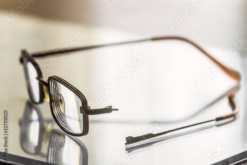 Eyeglasses with a broken handle. Limited depth of field.