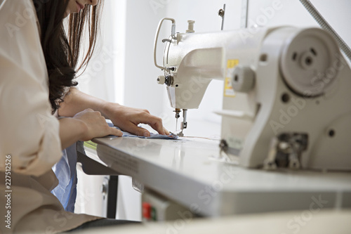 Canvas Print Mid section of fashion designer working on sewing machine