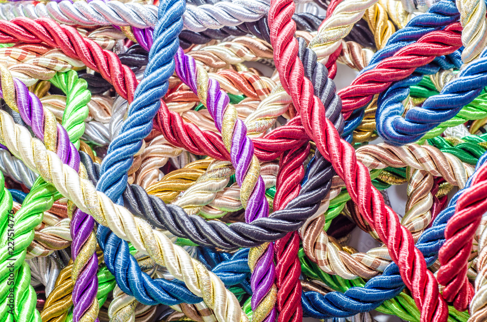 Decorative multicolored cords of ropes scattered in a chaotic manner. Textile industry, thread, decoration
