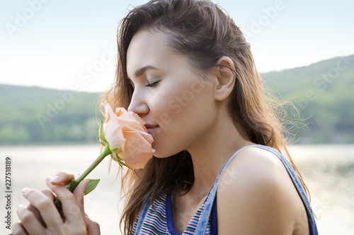 Fotografi Side view of woman smelling rose