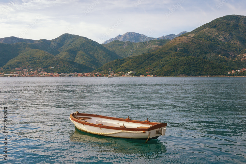 Beautiful Mediterranean landscape - mountains, sea and one fishing boat on the water. Montenegro, Adriatic Sea, Bay of Kotor Beautiful Mediterranean landscape - mountains, sea and one fishing boat on the water. Montenegro, Adriatic Sea, Bay of Kotor