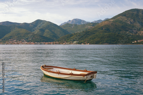 Beautiful Mediterranean landscape - mountains, sea and one fishing boat on the water. Montenegro, Adriatic Sea, Bay of Kotor