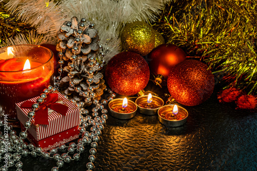 Wallpaper Mural Christmas and new year's composition of red balls for Christmas trees and Golden tinsel, in the light of candles on a dark background with space for text. Holiday gifts, surprises. Winter cones and or Torontodigital.ca