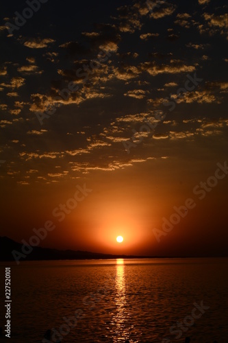 Beautiful blazing sunset landscape at Caspian Sea and orange sky above.