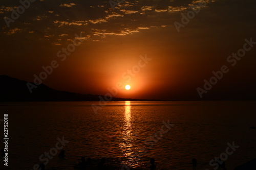 Beautiful blazing sunset landscape at Caspian Sea and orange sky above.