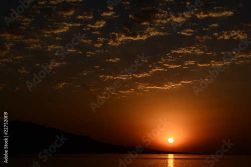 Beautiful blazing sunset landscape at Caspian Sea and orange sky above.