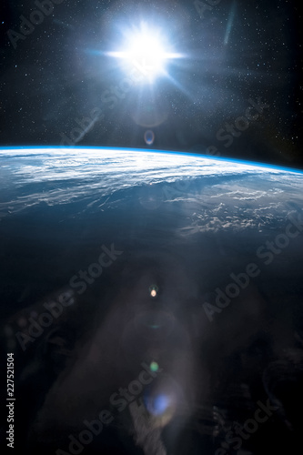 Fototapeta Naklejka Na Ścianę i Meble -  Part of earth with sun rise and lens flare background, Internet Network concept, vertical. Elements of this image furnished by NASA.