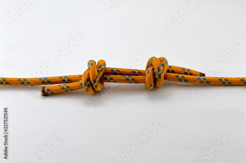 nodo inglese doppio arrampicata, corda arancione isolato fondo bianco