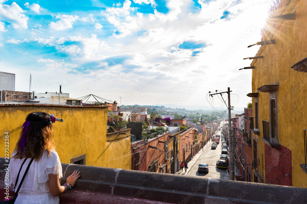 Obraz premium Girl with flower crown looking out at sunset at San Miguel de Allende Mexico