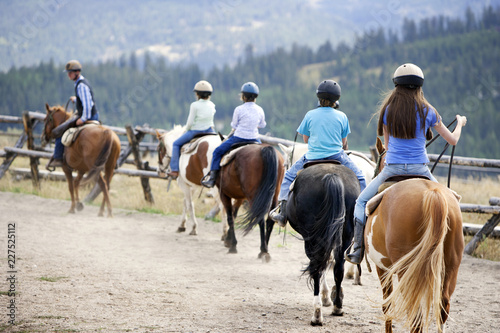 Vászonkép Children riding horses