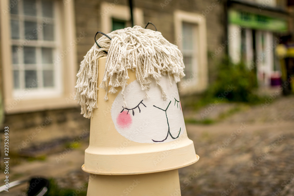 a head view of a llama made from flowerpots and a mop. 