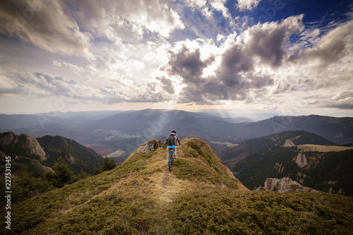Tableau sur toile Backpacker riding bicycle on mountain