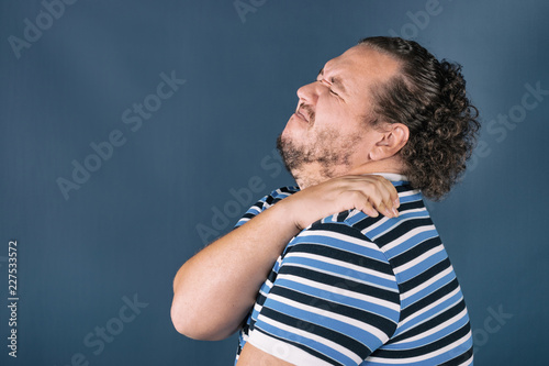 Konstfotografi Man holding his sore shoulder trying to relieve pain