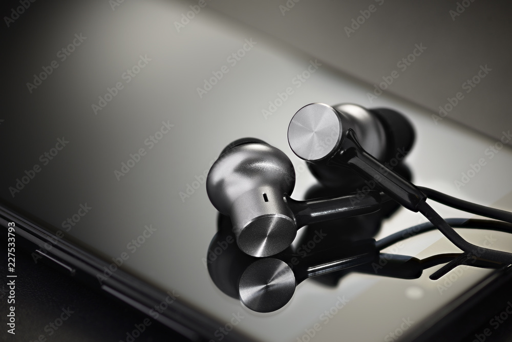 Obraz premium Earbuds on black smartphone