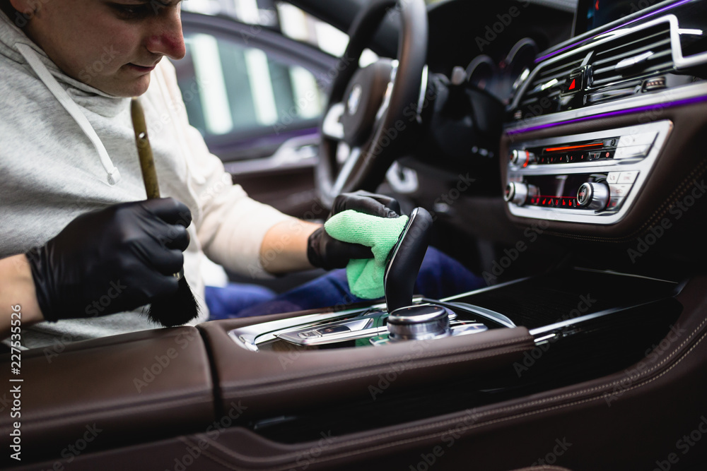 A man cleaning car interior, car detailing (or valeting) concept. Selective focus.