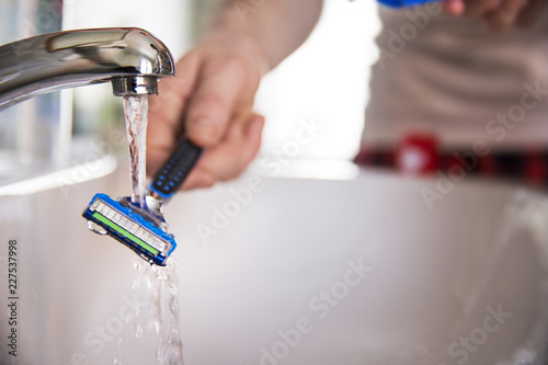 Close up of man washing razor