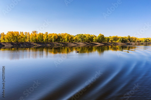 Foto Beautiful serene waterscape of Russian Volga river at autumn sunny day and colorful forest background
