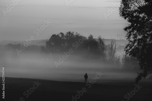 Fototapeta Naklejka Na Ścianę i Meble -  Man standing alone in darkness and fog