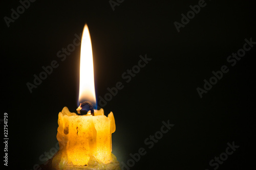A candle light in a dark soft background photo
