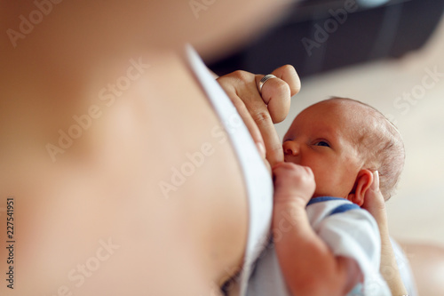 Mom breastfeeding baby - Woman feeding baby. Mother holding her newborn child. photo
