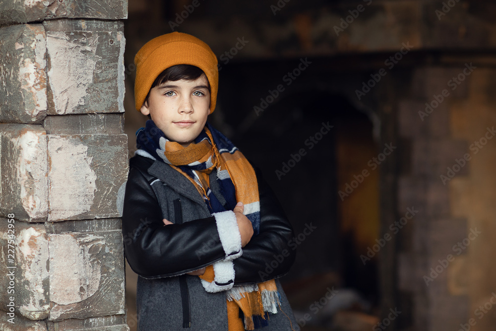 boy standing at brick wall of old house boy standing at brick wall of old house