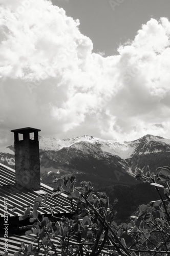 Country house with a view on mountains' peaks covered with a snow. Provence-Alpes-Cote d'Azur region of France. Black white historic photo.