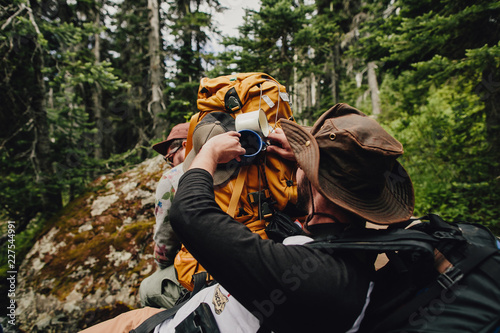 Boys getting cup from backpack on camping trip