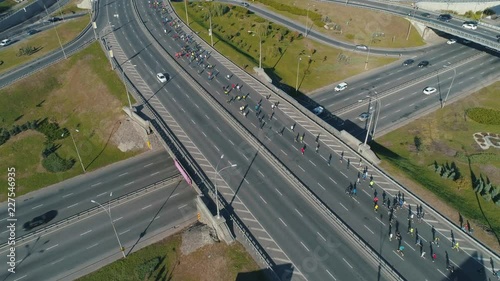 Aerial drone footage. Following marathon running group on the road junction photo