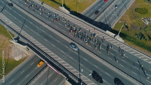 Aerial drone footage. Following marathon running group on the road junction, close up photo