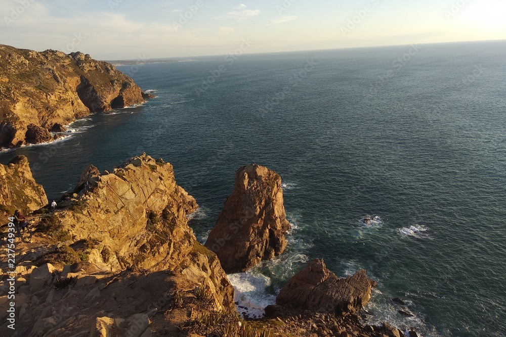 The rocks illuminate the sunlight at sunset. Atlantic Ocean, view from portugal