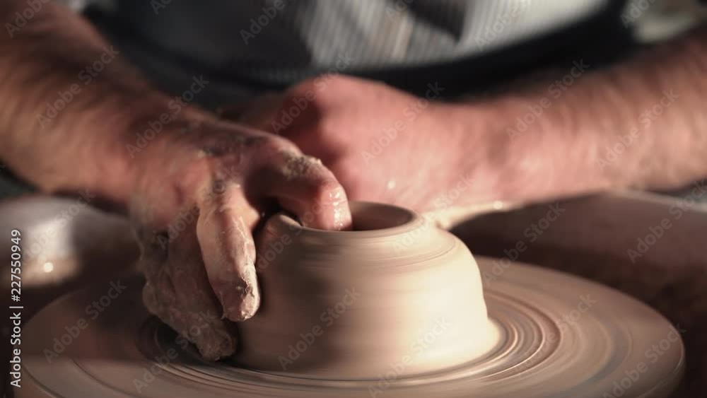 Creating earthenware and traditional pottery concept. Experienced male potter's hands creating beautiful clay product - bowl - using professional tools. Toned cinematic, craft factory authentic Creating earthenware and traditional pottery concept. Experienced male potter's hands creating beautiful clay product - bowl - using professional tools. Toned cinematic, craft factory authentic