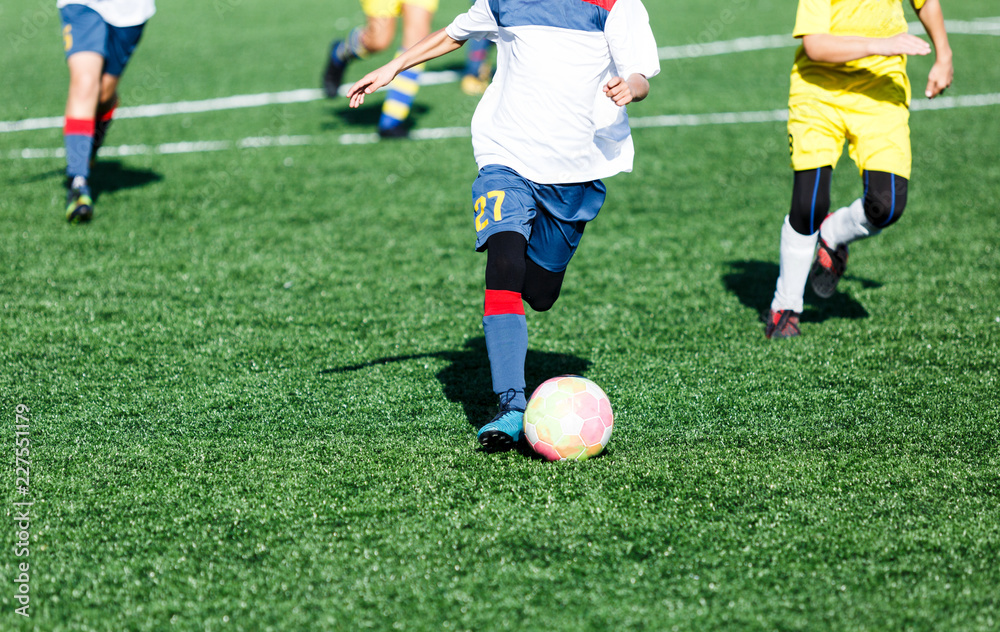 football teams - boys in red, blue, white uniform play soccer on the green field. boys dribbling. dribbling skills. Team game, training, active lifestyle, hobby, sport for kids concept football teams - boys in red, blue, white uniform play soccer on the green field. boys dribbling. dribbling skills. Team game, training, active lifestyle, hobby, sport for kids concept