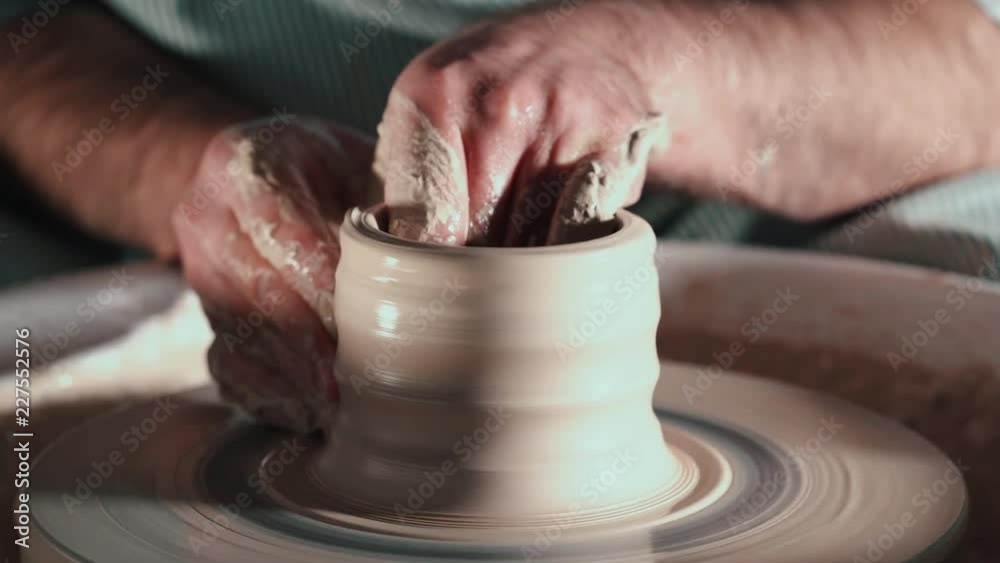 Creating earthenware and traditional pottery concept. Experienced male potter's hands creating beautiful clay product - bowl - using professional tools. Toned cinematic, craft factory authentic Creating earthenware and traditional pottery concept. Experienced male potter's hands creating beautiful clay product - bowl - using professional tools. Toned cinematic, craft factory authentic