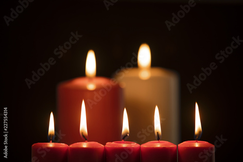Christmas candles illuminate on dark background