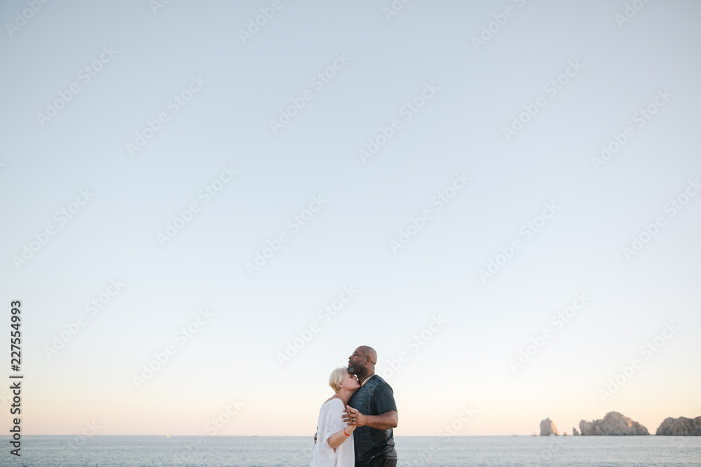 Fun middle aged couple enjoying quality time on the beach at sun Fun middle aged couple enjoying quality time on the beach at sun