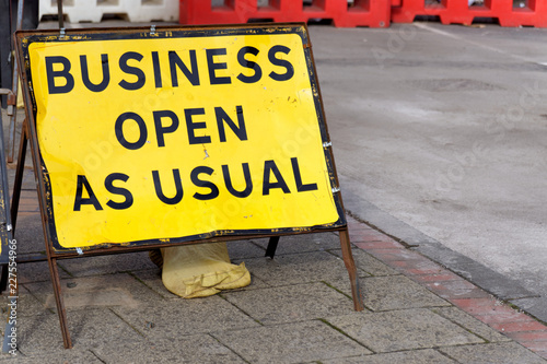 Yellow road sign stating business open as usual during period of road works
