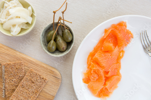 A scandinavian inspired light meal of smoked salmon, scandinavian crackers, pickled vegetable and caper berries. photo