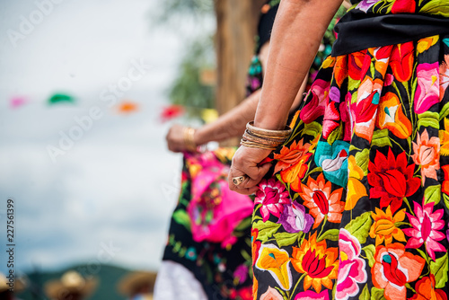 bailarinas con faldas floreadas bordadas a mano, mujeres de oaxaca con pulseras de oro en fiesta de la guelageutza photo